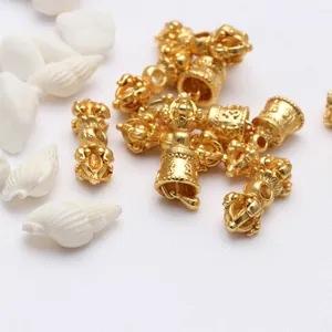 Dettaglio di pestelli Vajra e campane in oro antico per braccialetti buddisti fai da te.