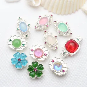Close-up view of various silver-plated hollow beads with colorful inset stones for DIY jewelry