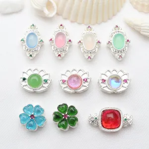 Detailed macro view of silver-plated hollow spacer beads with colorful inlaid stones