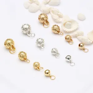Detailopname van 14k gouden en zilveren belhangers voor doe-het-zelf sieraden maken