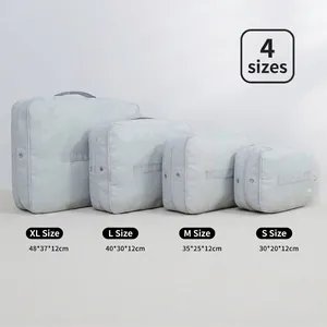 Set of 4 grey waterproof travel packing cubes in various sizes for luggage organization.
