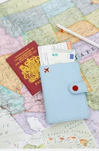 Premium light blue PU leather passport holder with red airplane icon on travel map background