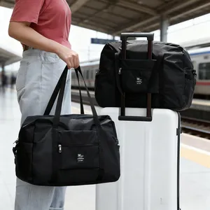Large capacity waterproof black travel duffel bag with a luggage trolley sleeve.