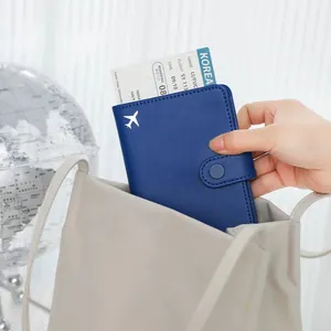 High-quality blue PU leather RFID passport holder with airplane motif shown in a travel bag