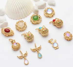 Various sand gold enamel charms and pendants for DIY jewelry making on white textured surface.