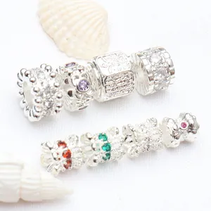 Macro detail of micro-pave zircon silver-plated spacer beads displayed with seashell props