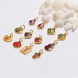 Detailed view of various traditional Chinese enamel charms with an antique gold finish