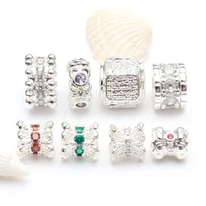 Detailed macro view of assorted silver-plated zircon beads and spacers for jewelry making.