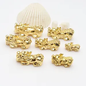 Close-up detail of various sized gold-plated Pixiu charms for DIY jewelry bracelet making