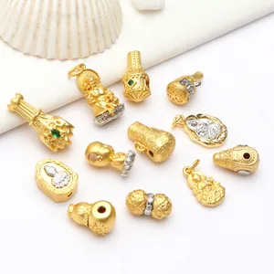 Detalle de primer plano de dijes de Buda y Ganesha en oro antiguo para creación de joyería