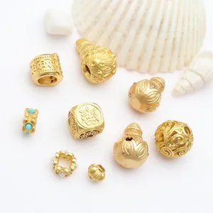 Close-up of ancient gold DIY jewelry beads including hollow gourds and filigree spacers