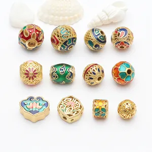 Detailansicht verschiedener bunter Emaille-Cloisonné-Goldperlen für DIY-Schmuckherstellung.