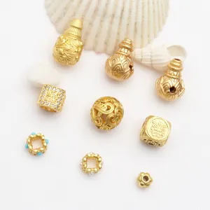 Detailed view of ancient sand gold hollowed beads and hulu charms for DIY jewelry making.