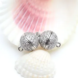 Primer plano de cierres magnéticos redondos con micro-pave para joyas DIY en conchas blancas