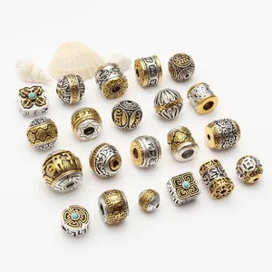 Tibetan silver and gold style beads with auspicious cloud and mantra engraving details.