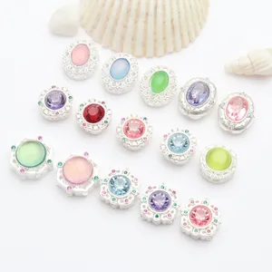 Detail view of various silver-plated DIY beads with colorful inlaid stones and crystals
