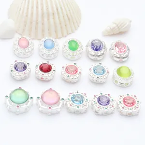 Detailed view of various matte silver plated spacer beads with colorful inlaid stones for DIY jewelry.