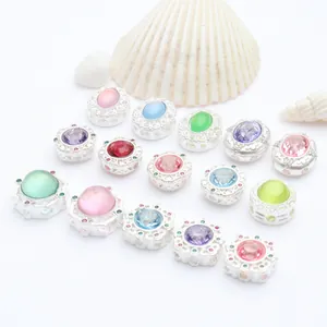 Detail view of DIY matte silver spacer beads with colorful inset stones and seashell props.
