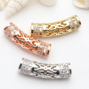 Close-up of hollow curved tube spacer beads with micro-pave zircon and heart patterns