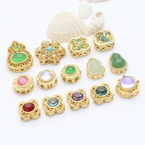 Detailed view of assorted enamel gold spacer beads with colorful stones and pearls.