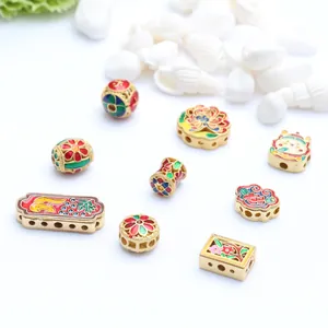 Close-up of ancient gold craft beads with colorful enamel flower patterns for jewelry DIY