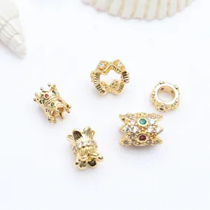 Detailed view of various golden micro-inset zircon spacers for DIY bracelet making