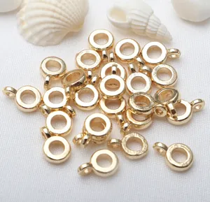 Close-up macro detail of 18K gold plated round ring charms for DIY jewelry making findings