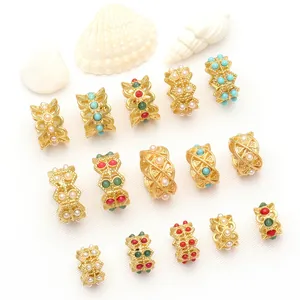 Vue macro détaillée de breloques de bijoux DIY dorées avec perles colorées et nacrées