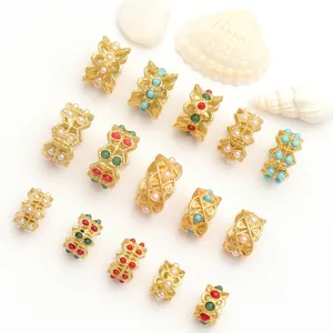 Assortiment de perles d'espacement dorées pour bijoux avec perles sur fond blanc