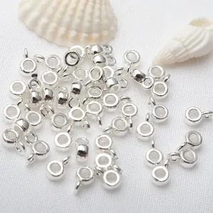 Macro view of silver-plated round pendant rings for DIY jewelry making and craft projects.