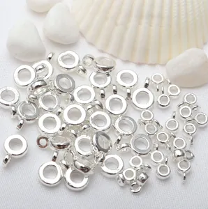 Macro detail of round silver-plated pendant bail connectors for jewelry making