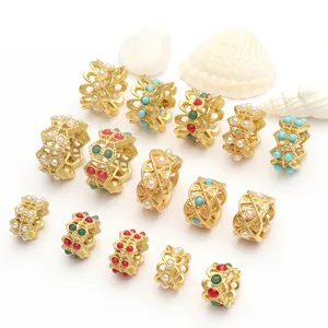 Vue détaillée de diverses perles dorées avec perles et pierres colorées pour bijoux.