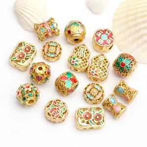 Detailansicht verschiedener vergoldeter Cloisonné-Emaille-Perlen für die Schmuckherstellung.