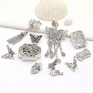 Vue macro détaillée montrant des pendentifs papillon vintage en alliage d'argent tibétain.