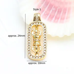 Detailed view of a rotating 18K gold plated Vajra pendant with zircon, 24x10mm