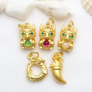 Detailed macro shot of antique gold dragon pendants featuring vibrant stone inlays