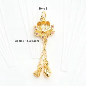 Detail view of 18K gold-plated lotus pendant with red zircon and dangling charms