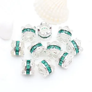 Macro detail of emerald green zircon waist spacer beads with ornate silver scalloped edges