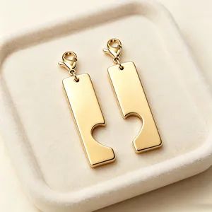 Vue détaillée de pendentifs cœur puzzle en or poli avec fermoirs mousquetons.