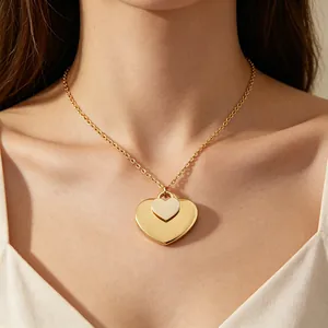 Detailansicht einer eleganten goldenen Halskette mit Doppelherz-Anhänger am Model.