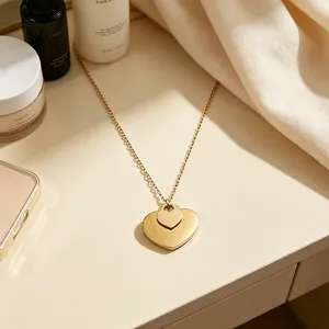 Detailansicht des eleganten goldfarbenen Doppelherz-Anhängers an einer feinen Kette.