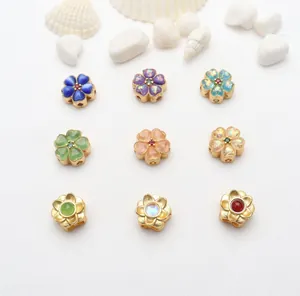Makroansicht verschiedener bunter vergoldeter Blumen-Zwischenperlen für DIY-Schmuck