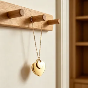 Detaillierte Nahaufnahme einer goldenen Herzkette an einer minimalistischen Wandgarderobe aus Holz