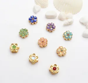 Detailansicht verschiedener bunter blumenförmiger goldfarbener Schmuckperlen für DIY-Sets