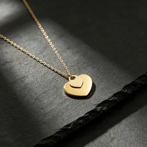Elegante Halskette mit zwei Herzanhängern aus poliertem goldenem Edelstahl