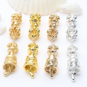 Detailed metal Vajra bell and pestle charms in gold and silver for DIY jewelry making.