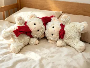 Detalle de lindos muñecos de peluche de oveja blanca con bufandas y gorro