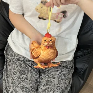 Creativo y divertido peluche híbrido de gato y pollo sostenido a mano para detalle
