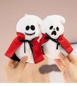 Close-up of two cute Halloween plush ghosts wearing red capes held by hands for gift display