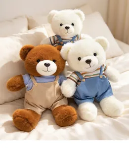 Three cute soft couple teddy bear plush toys wearing colorful overalls on a cozy bed